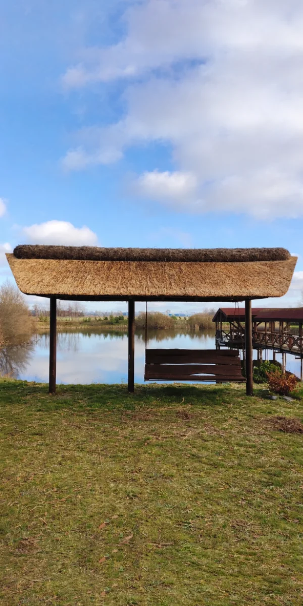 Thatched-roof lakeside shelter with bench