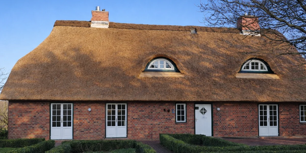 Brick cottage with thatched roof and dormer windows