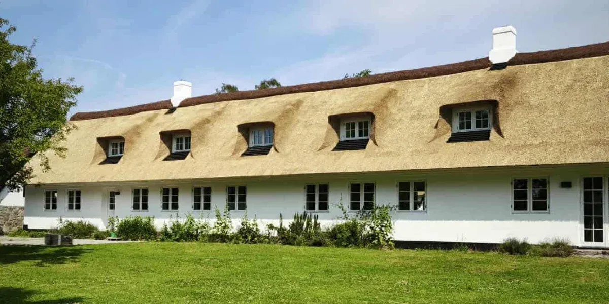 Long White House with Reed Thatched Roof and Dormer Windows