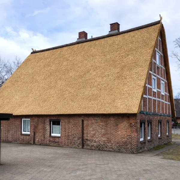 Large Traditional Reed Thatched Roof on Brick Farmhouse